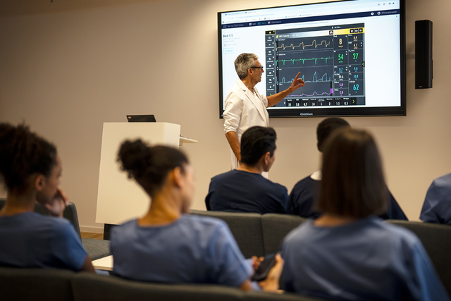 Intensive care doctor holding ventilation training utilizing TwinView remote view outside the ICU