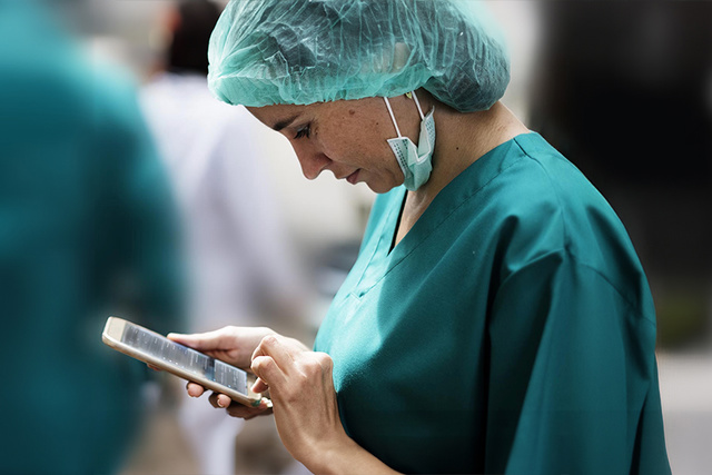Female doctor checking Talis data on mobile phone