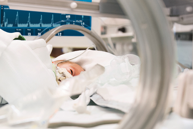 Newborn in an incubator with the Servo-n ventilator display