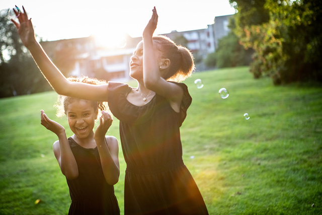 Girls on the meadow playing with soap bubbles