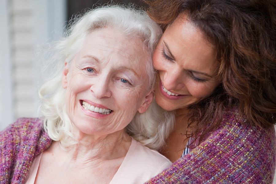 Women in a hug smiling