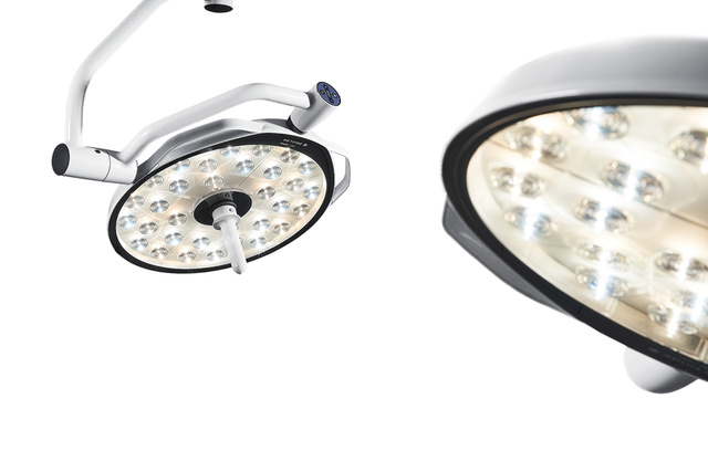 白い背景に、複数の LED 電球と白いフレームを備えた 2 つの手術用照明器 Maquet Ezea