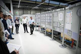 Team meeting in front of boards in a factory environement