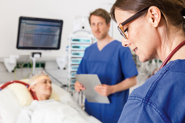 Two nurses next to a patient