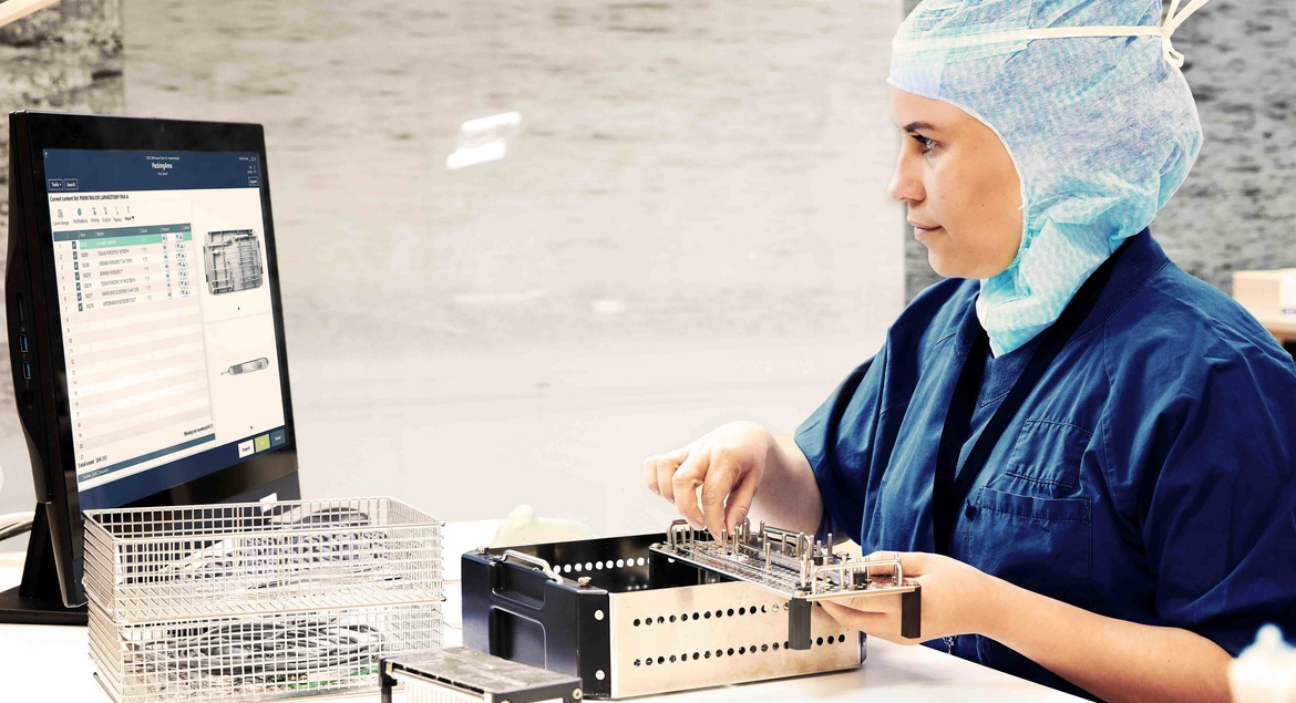 Sterile assistant packing instrument tray with help from instructions in T-DOC