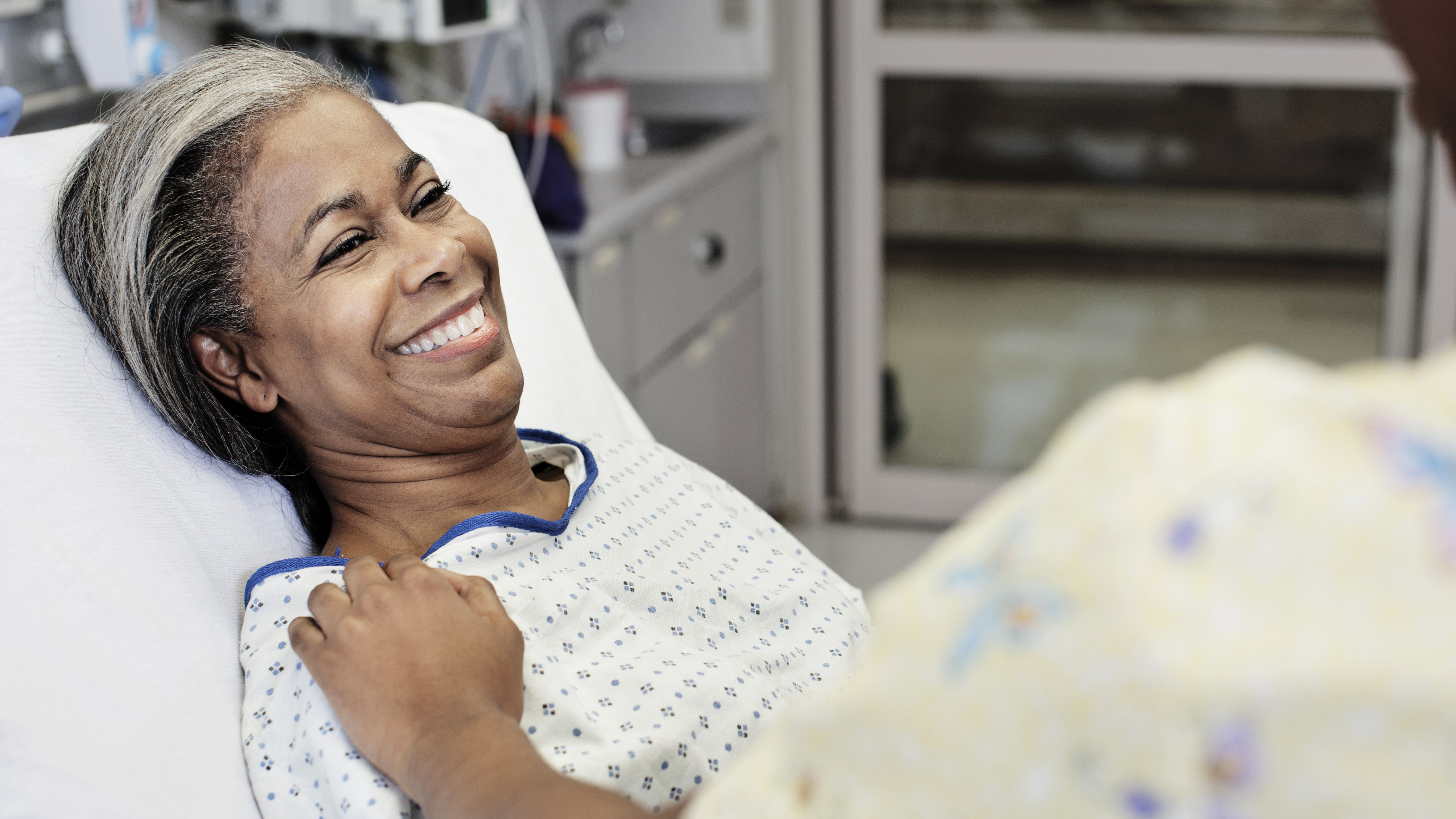 Patient laying in hospital room smiling