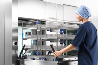 Worker in front of washer disinfector 