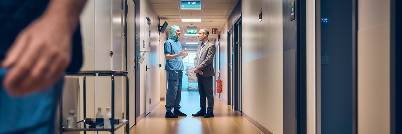Doctor and businessman talking in a hospital corridor