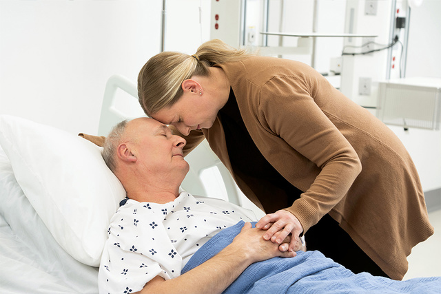 Patient in hospital bed with wife