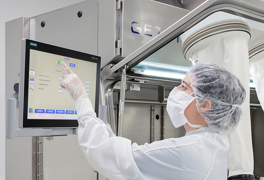 An operator using the isolator's HMI to run a test using a Glove Leak Tester An operator using the isolator's HMI to run a test using a Glove Leak Tester