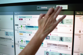 close up of a hand working on the Getinge Ingsight patient flow management software screen