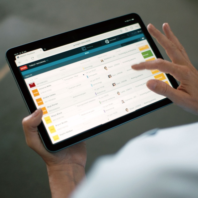 Nurse using INSIGHT patient flow management solution on a tablet to manage the patient flow from arrival to discharge