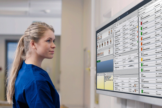 Nurse in front of a big INSIGHT screeen looking at the patient list with the next medical activities