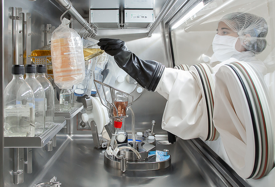 An operator performing sterility testing in an ISOFLEX isolator.