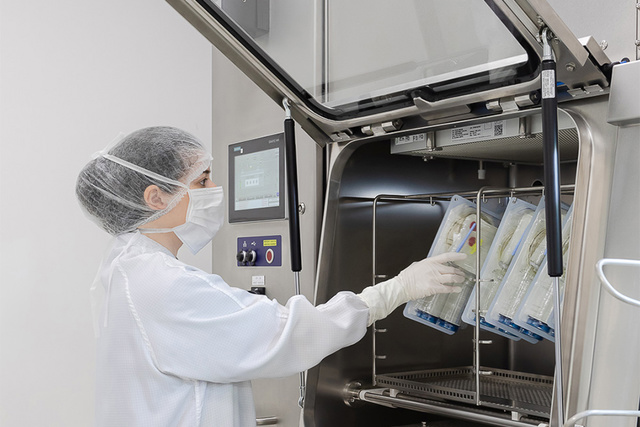 Operator loading the ISOPRIME isolator's transfer hatch