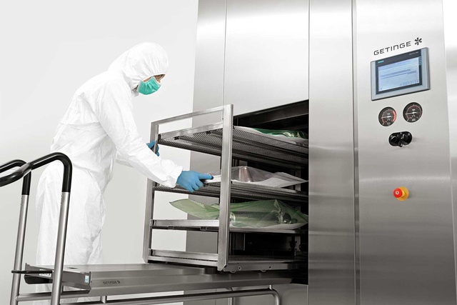 A man is loading the GSS Steam Sterilizer with equipment for biopharmaceutical production 