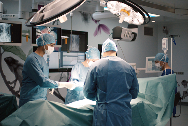 Ongoing surgery with medical staff in a operting room, different IT solutions working together