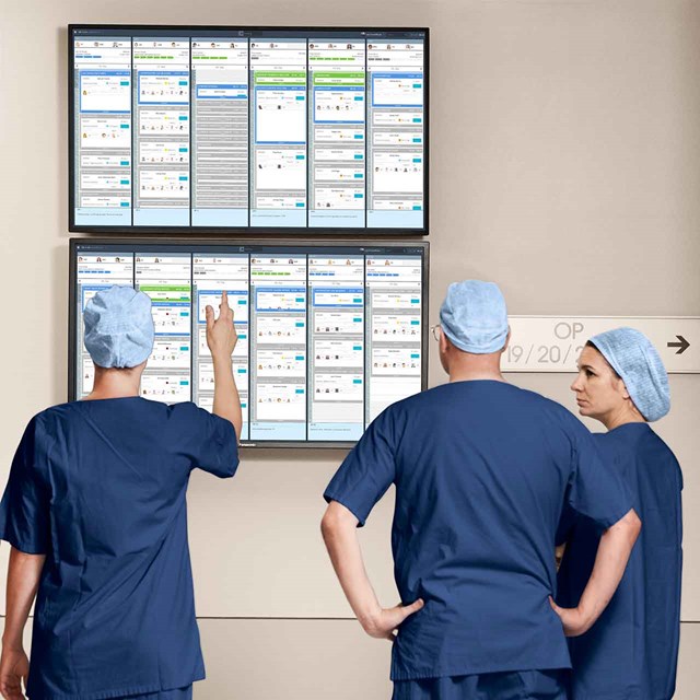 OR staff discussing OR schedule by screen in the surgical department with Getinge’s OR Management solution Torin