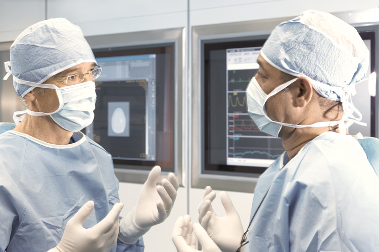 doctors with gloves speaking in front of a screen doctors with gloves speaking in front of a screen