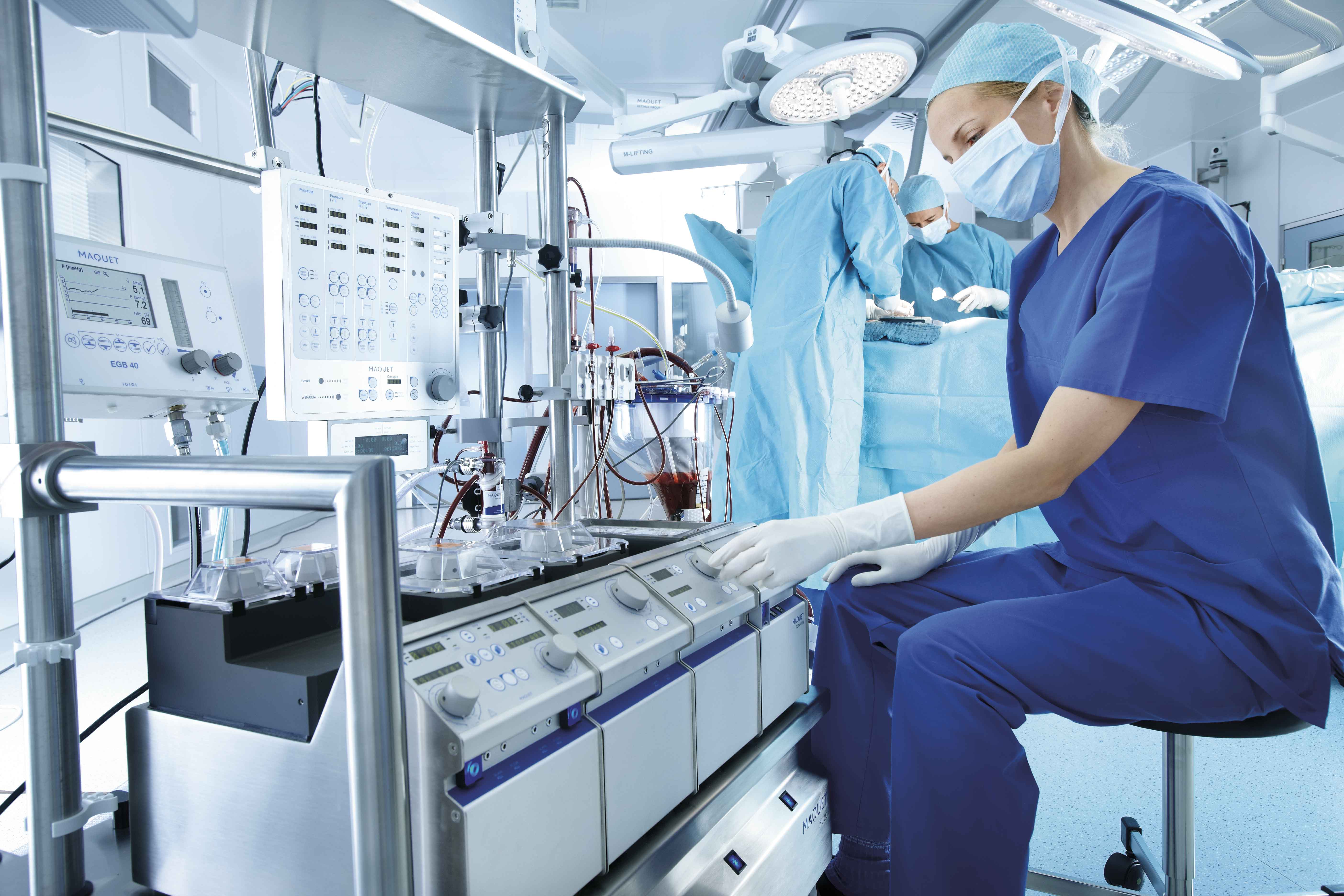 Doctor sitting and setting the surgical perfusion system Doctor sitting and setting the surgical perfusion system