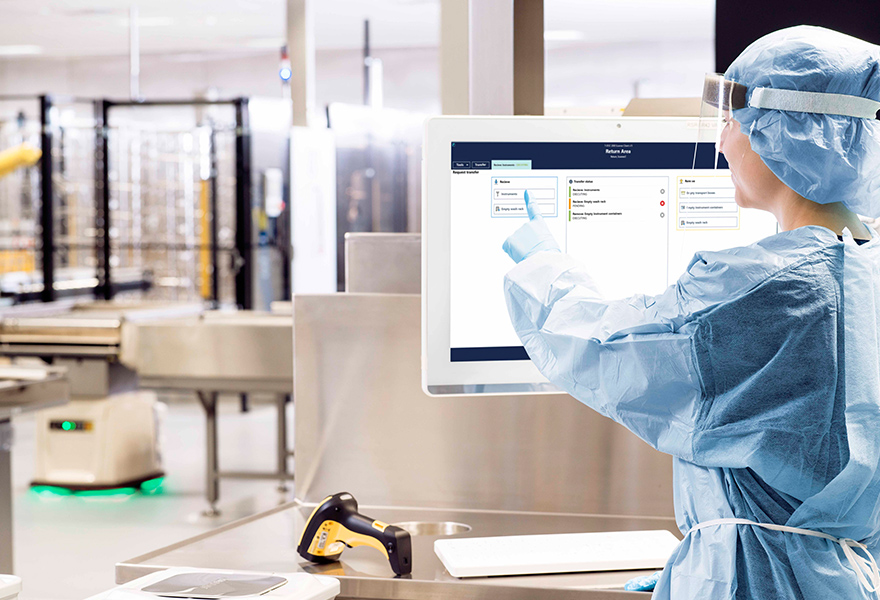 Sterile assistant working with a T-DOC in an automated CSSD Sterile-staff-working-with-T-DOC-touch-screen