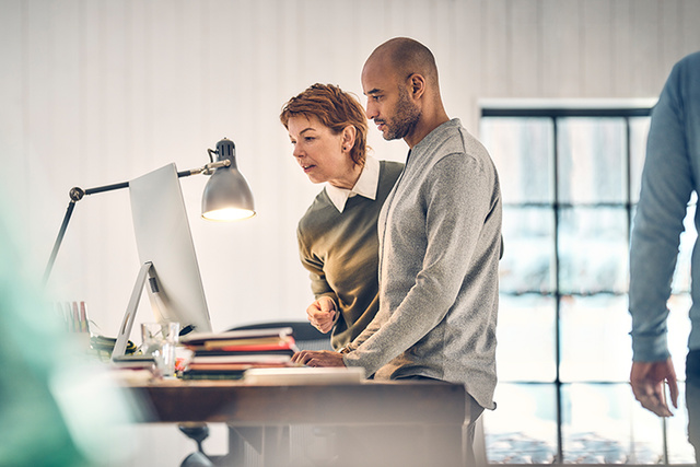 Two designers viewing a sketch at a large computer screen