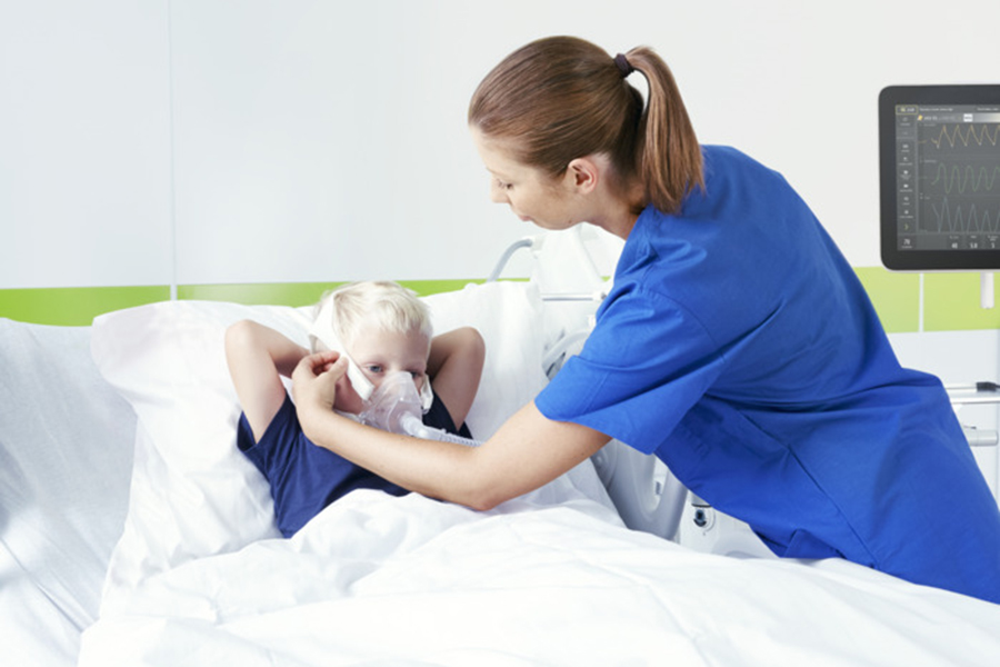 Nurse with child patient, applying nebulizer