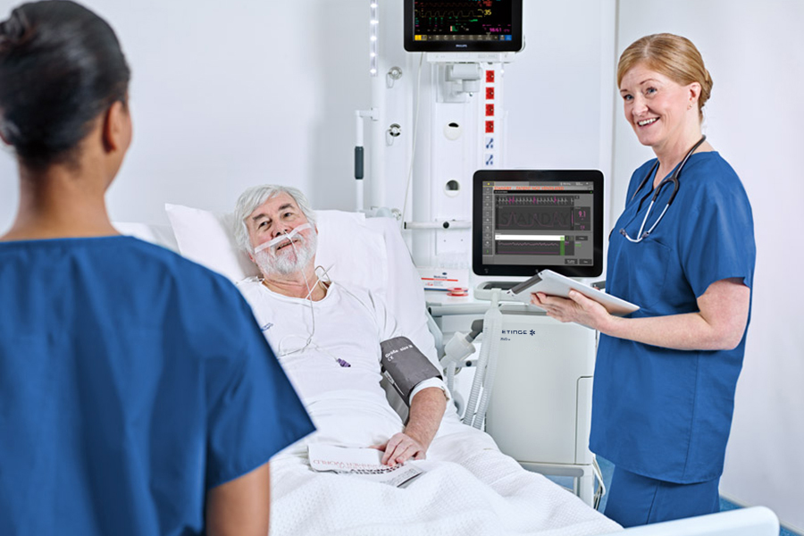 Two nurses standing next to a patient under servo-u Two nurses standing next to a patient under servo-u