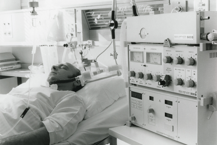 The Servo 900 successor the Servo 900B mechanical ventilator connected to adult patient lying in a hospital bed The Servo 900 successor the Servo 900B mechanical ventilator connected to adult patient lying in a hospital bed
