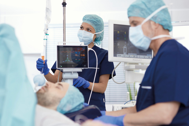 Nurses monitoring patient in operating room