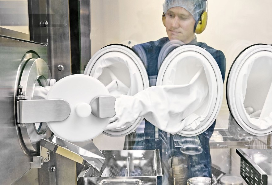 An operator using a DPTE® Alpha port and DPTE-BetaBag® to transfer components in a filling line An operator using a DPTE® Alpha port and DPTE-BetaBag® to transfer components in a filling line