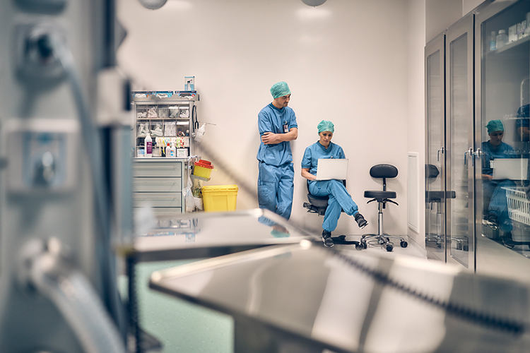 Hospital staff in storage area looking at laptop screen