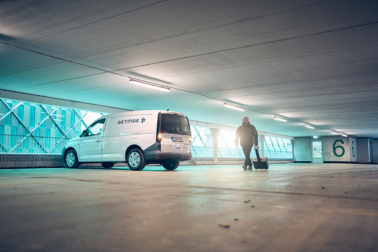 Getinge service car and technician in parking garage