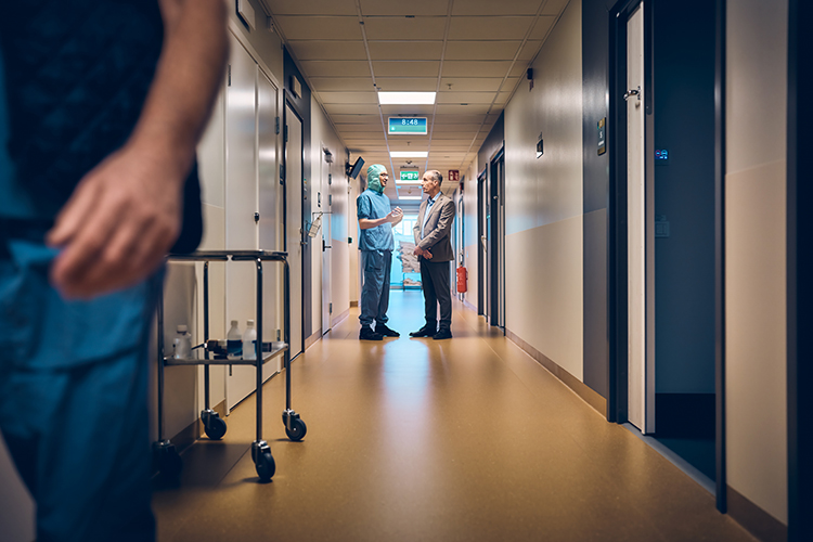 Doctor and businessman talking in a hospital corridor