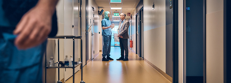 Doctor and businessman talking in a hospital corridor