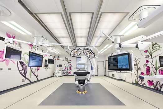 Bloc opératoire hybride avec équipements médicaux et écrans.